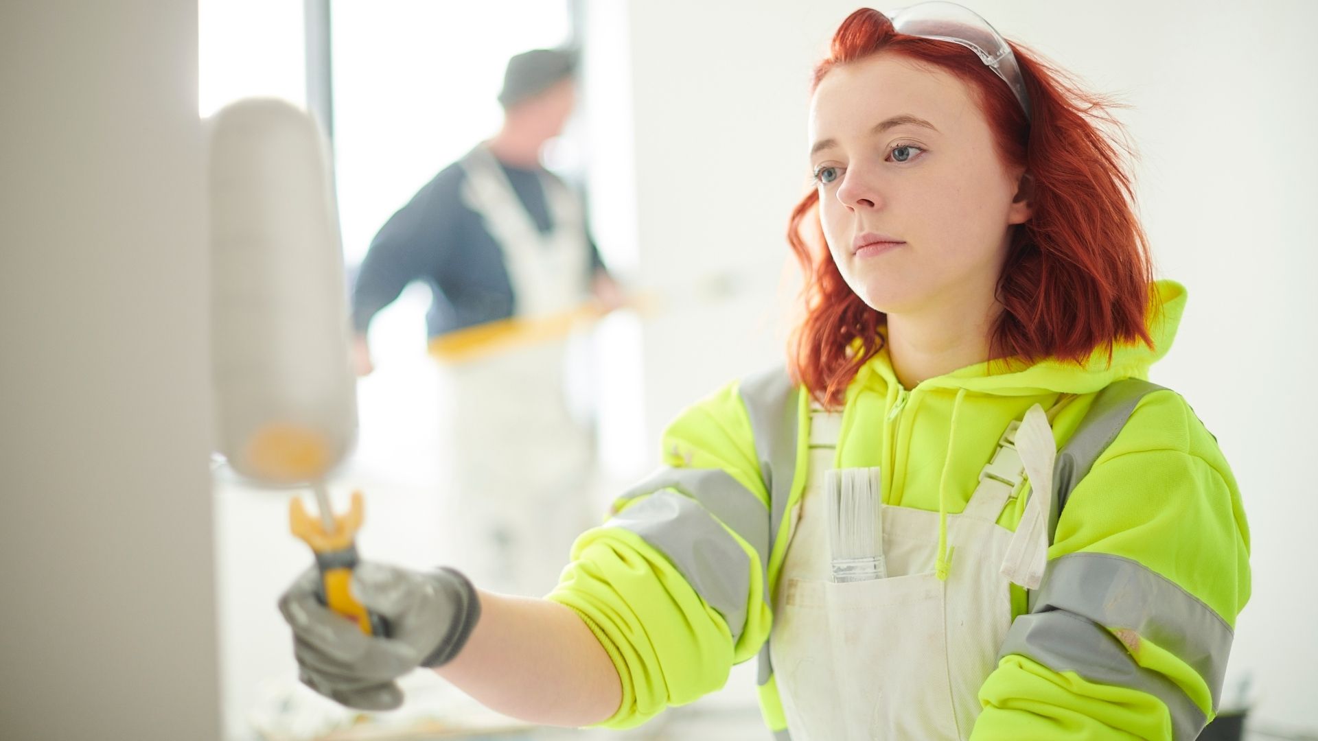 Nuori henkilö maalaa seinää.